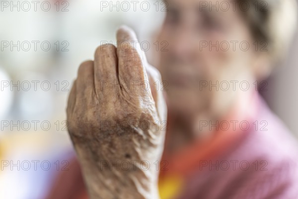 Over 90-year-old senior citizen with dementia talks and gesticulates with her wrinkled hands in a retirement home, Cologne, North Rhine-Westphalia, Germany