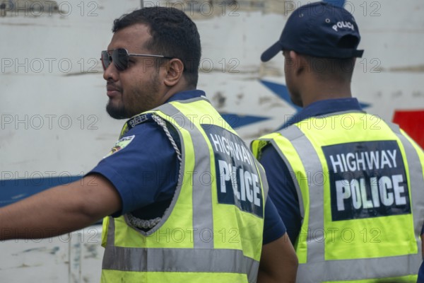Two highway police officers in reflective vests coordinating together, Dhaka, Bangladesh