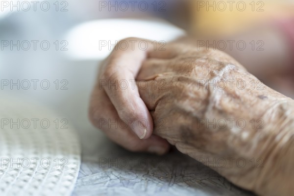 Wrinkled hands of a 90+ year old senior citizen lying on the table in a retirement home, Cologne, North Rhine-Westphalia, Germany