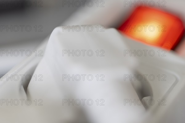 Close-up of a white power plug, Schuko plug, plugged into a multiple socket with red indicator light, symbolic image for electricity, electrical energy, power consumption, studio shot, Germany