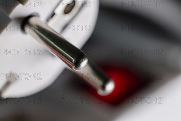 Close-up of a white power plug, Schuko plug, on a multiple socket with red indicator light, symbolic image for electricity, electrical energy, power consumption, studio shot, Germany