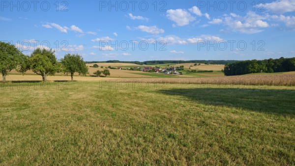 Rural scene with a view of a village and surrounding fields under a blue sky, Reichartshausen, Amorbach, Odenwald, Bavaria, Germany