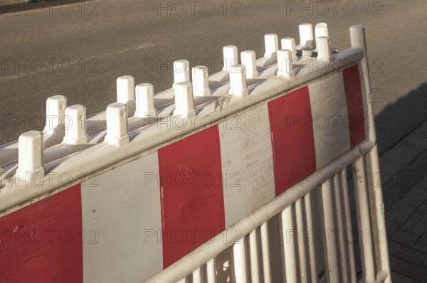 Borken, NRW, Germany, Red and white striped traffic barrier standing on a city street, ensuring safety and regulating traffic flow