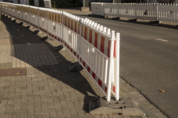 Borken, NRW, Germany, Red and white plastic road barriers creating a division between sidewalk and street, ensuring safety and traffic management