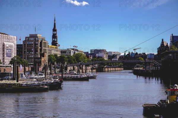 A busy harbour with many boats, a bridge and urban architecture under a clear sky. View from the Niederbaumbrücke to the inland harbour in 20457 Hamburg, Germany