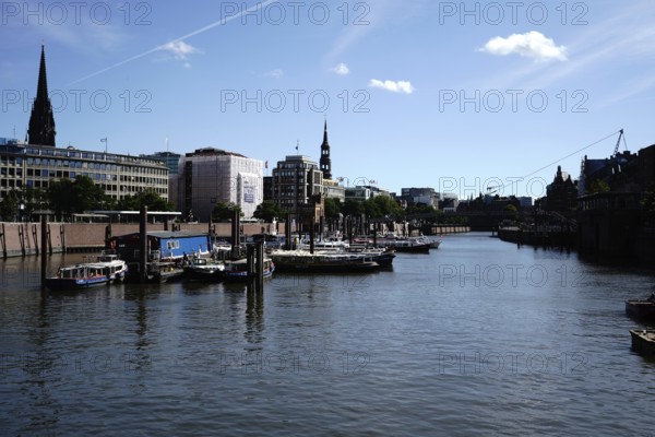 A quiet harbour with boats and modern architecture under a clear blue sky. View from the Niederbaumbrücke to the inland harbour in 20457 Hamburg, Germany
