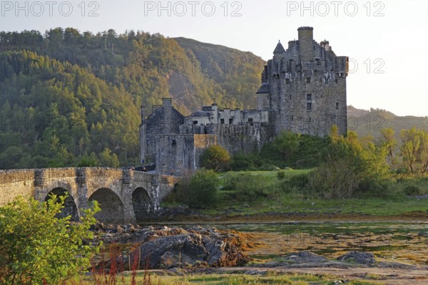 Historic castle on an inlet with dramatic mountains in the background, Eilean Donan Castle, Highlander, film set, Scotland, Great Britain