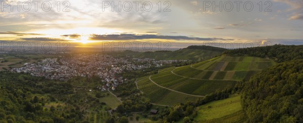 A town stretches out between green hills in the warm light of the sunset, Korb im Remstal, Baden-Württemberg, Germany