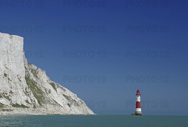 Red lighthouse in front of white cliffs at the blue sea, Old Harrys Rock, Beachy Head Lighthouse, Bournemouth, Dorset, England, Great Britain