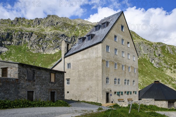 View of building Ospizio Hospiz Herberge San Gottardo St. Gotthard built from 1230 in the 13th century with small entrance door main entrance on pass summit of Gotthard Pass, Swiss Alps, Airolo, Canton Ticino, Ticino, Switzerland