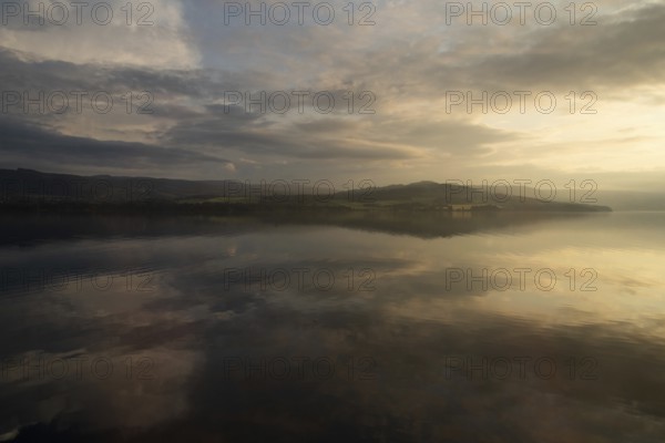 The sky and clouds are reflected on the surface of Lake Mjøsa or Mjosa just in front of sunset, near Hamar, Norway