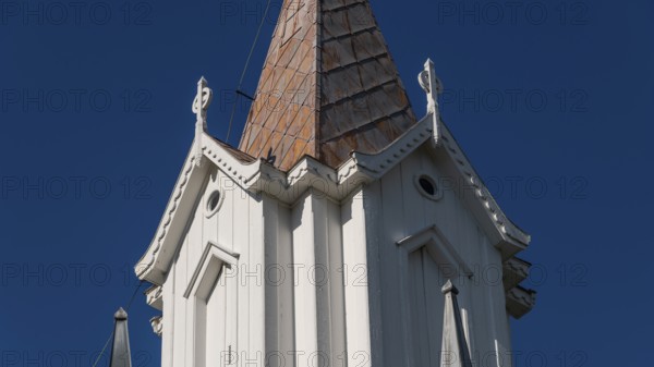 Pointed church tower with wooden elements and clear blue sky in the background, Tangen kirke or church, Olavsweg or Olavsleden, pilgrimage route, Tangen, Stange municipality, Norway