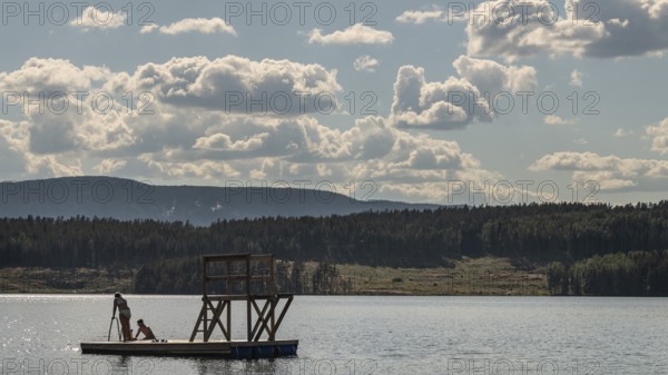 Children playing on a platform at a bathing place at Lake Mjøsa or Mjosa with wooded shore, Olavsweg or Olavsleden, near Tangen, Norway