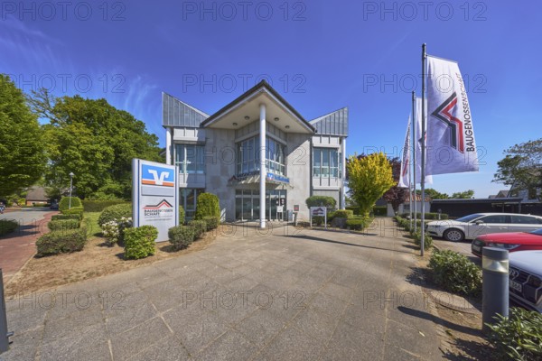 Vereinigte Volksbank eG - Filiale Alfhausen, Baugenossenschaft Landkreis Osnabrück eG, flags on flagpoles, modern architecture, street, car park with vehicles, flower bed, trees, hedge, blue sky, cirrostratus clouds, Hauptstraße, Alfhausen, Landkreis Osnabrück, Lower Saxony, Germany