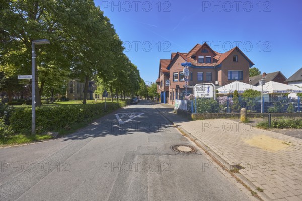 Restaurant Zum alten Pauker, clinker brick building, general development, historic cemetery, trees, lawn, street, blue sky, cloudless, intersection Alte Schulstraße with Rosenstraße, Alfhausen, district of Osnabrück, Lower Saxony, Germany