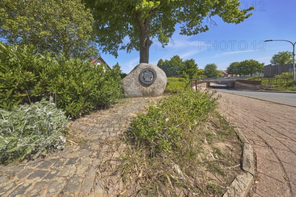 Monument, political event, reunification, flower bed, bushes, trees, cobblestone path, frog perspective, blue sky, cirrostratus clouds, Alte Schulstraße, Alfhausen, district of Osnabrück, Lower Saxony, Germany