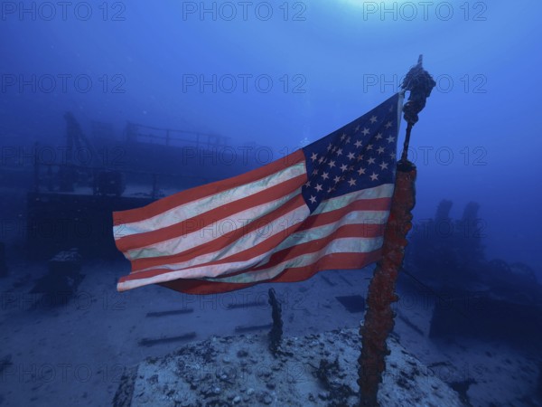 USA flag on a wreck under water, surrounded by deep blue. Dive site Wreck of the USS Spiegel Grove, John Pennekamp Coral Reef State Park, Key Largo, Florida Keys, Florida, USA