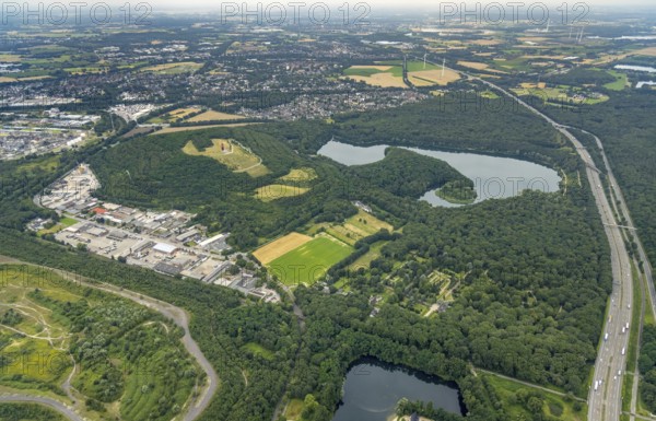 Aerial view, forest lake and slagheap Rheinpreussen, industrial area Gutenbergstraße, cemetery Lohmannsheide, Bärl, Duisburg, city limits Mörs, Ruhr area, North Rhine-Westphalia, Germany, motorway A42, burial site, slagheap, DE, Europe, cemetery, memorial, Geleucht Grubenlampe, commercial enterprises, commercial area, industrial area, commercial location, commercial use, Gottesacker, graves, burial ground, slag heap, slag heap landscape, slag heap sign, industrial area, industrial location, landmark, aerial view, aerial photography, aerial photography, Mörs, resting place, lake, symbol, overview, bird's-eye view, forest area, colliery slag heap, birds-eyes view, overview