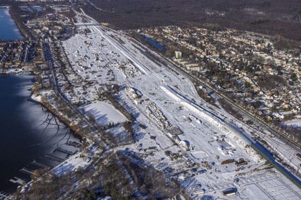 Aerial view, former Wedau marshalling yard, water tower, planned new Duisburg residential quarter, Wedau, Duisburg, Ruhr area, North Rhine-Westphalia, Germany, railway tracks, construction work, construction vehicles, construction area, construction site, construction project, construction site, DE, development, Europe, railway tracks, industrial plants, industrial area, industrial site, Kalkweg, capacity requirements, aerial view, aerial photography, aerial photography, redevelopment, snow, overview, connection Bissingheim and Wedau, bird's eye view, water tower in railway depot, winter, birds-eyes view, derelict railway area, cleared roads, overview
