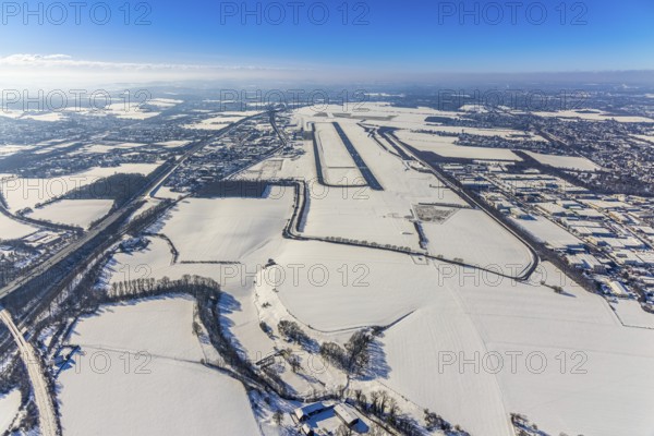 Aerial photo, Dortmund airport in winter, Wickede, Dortmund, Ruhr area, North Rhine-Westphalia, Germany, DE, Europe, flight mission, airport, airfield, runway, aerial photo, aerial photography, aerial photography, snow, runway, overview, bird's-eye view, winter, onset of winter, winter landscape, birds-eyes view, overview, cleared runway, taxiways terminal, general aviation, EDLW, General aviation, city limits Holzwickede
