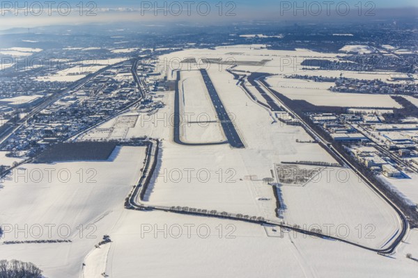 Aerial photo, Dortmund airport in winter, Wickede, Dortmund, Ruhr area, North Rhine-Westphalia, Germany, DE, Europe, flight mission, airport, airfield, runway, aerial photo, aerial photography, aerial photography, snow, runway, overview, bird's-eye view, winter, onset of winter, winter landscape, birds-eyes view, overview, cleared runway, taxiways terminal, general aviation, EDLW, General aviation, city limits Holzwickede