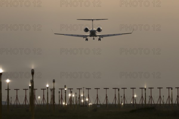 Bombardier Global business jet passenger aircraft in flight landing at sunset at London Stansted airport, Essex, England, United Kingdom