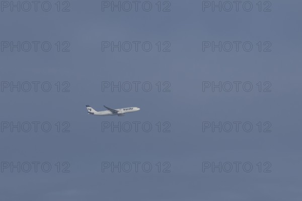 Jet passenger aircraft of Iran Air Airlines flying in a blue sky, England, United Kingdom
