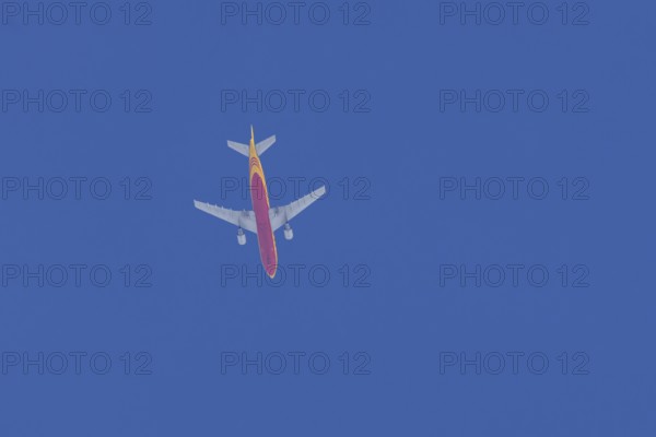Boeing 767 jet aircraft of DHL cargo airlines in flight in a blue sky, England, United Kingdom