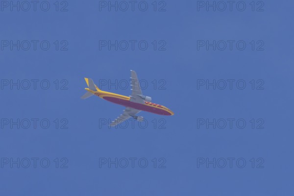 Boeing 767 jet aircraft of DHL cargo airlines in flight in a blue sky, England, United Kingdom