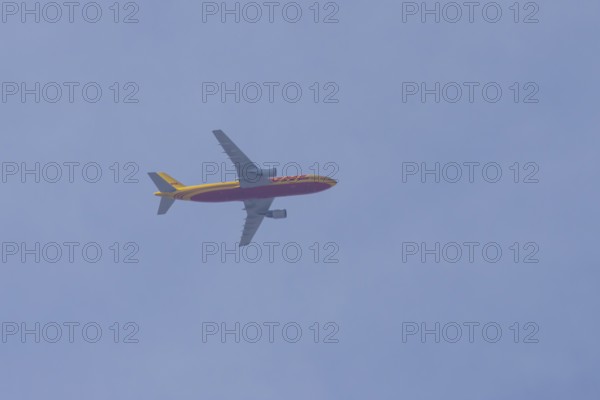 Boeing 767 jet aircraft of DHL cargo airlines in flight in a blue sky, England, United Kingdom