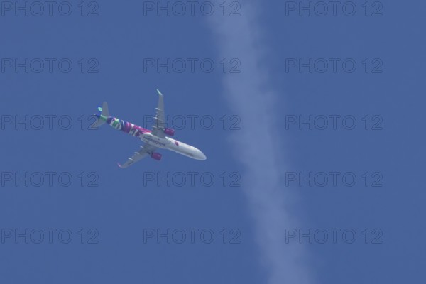Airbus A321 jet aircraft of Wizz Air airlines in flight in a blue sky, England, United Kingdom