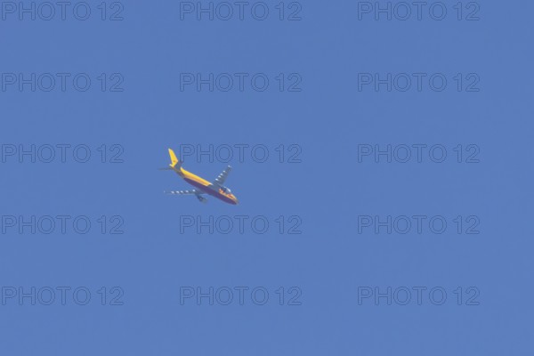 Boeing 767 jet aircraft of DHL cargo airlines in flight in a blue sky, England, United Kingdom