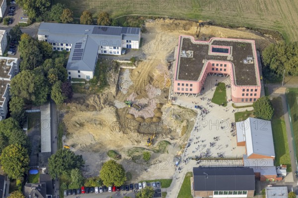 Aerial view, Pink building of the Reinoldi comprehensive school and construction site in the Bodelschwingh district of Dortmund, Ruhr area, North Rhine-Westphalia, Germany, construction work, construction area, construction site, building plots, construction project, construction site, educational institution, DE, Dortmund, Europe, comprehensive school, teaching institute, aerial photograph, aerial photography, aerial photography, new building, school, overview, bird's eye view, bird's eye view, overview