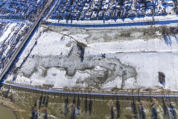 Aerial view, ice rink, ice skaters and pedestrians on frozen Rhine meadow in Lörrick near the Theodor-Heuss-Bridge, Niederkassel, Düsseldorf, Rhineland, North Rhine-Westphalia, Germany, DE, Europe, shapes and colours, aerial view, aerial photography, aerial photography, ice skating, snow, overview, bird's eye view, winter, birds-eyes view, overview