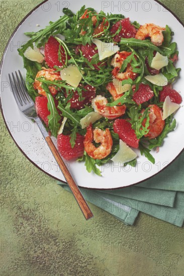 Fresh shrimp salad with arugula, grapefruit, and parmesan served in a bowl