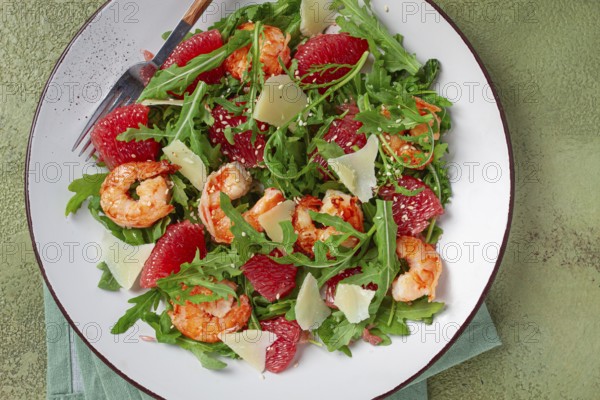 Fresh shrimp salad with arugula, grapefruit, and parmesan served in a bowl