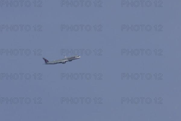 Airbus A350 jet passenger aircraft of Qater airlines flying in a blue sky, England, United Kingdom
