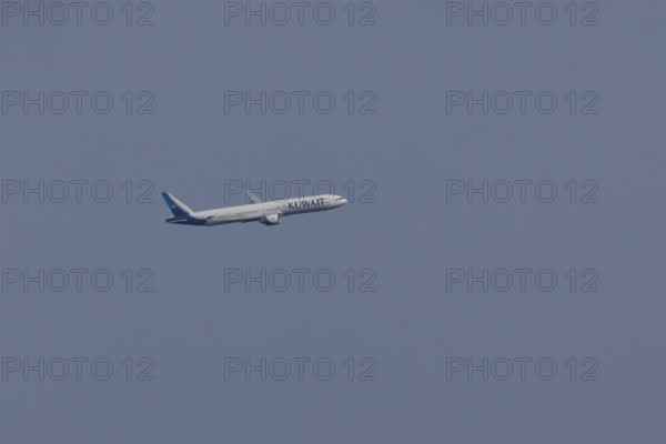 Boeing 777 jet passenger aircraft of Kuwait airlines in flight in a blue sky, England, United Kingdom