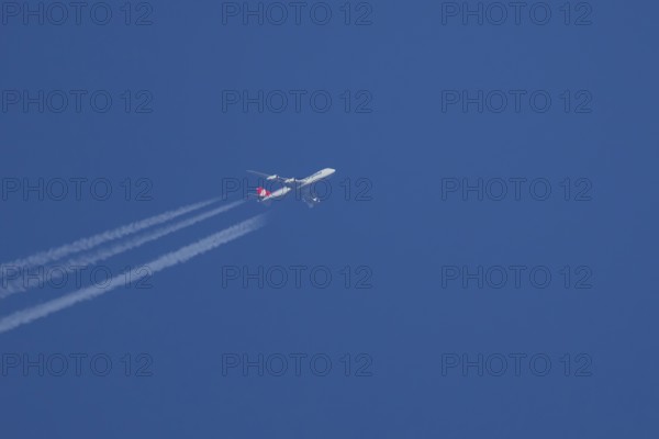 Boeing 747 Jumbo jet cargo aircraft of Cargolux airlines in flight in a blue sky with vapour trails or contrails behind, England, United Kingdom