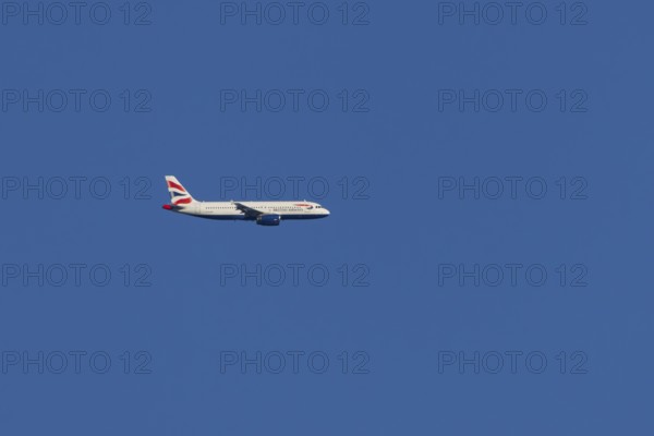 Airbus A320-232 jet passenger aircraft of British Airways airlines in flight in a blue sky, London, England, United Kingdom