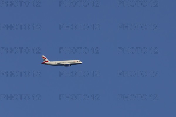 Airbus A320-232 jet passenger aircraft of British Airways airlines in flight in a blue sky, London, England, United Kingdom