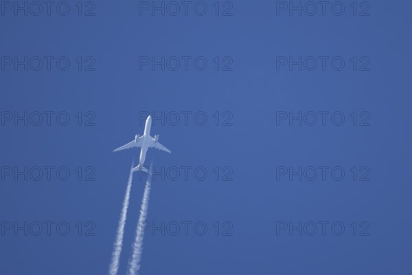 Airbus A350-900 passenger jet aircraft of Singapore airlines flying with a vapour trial or contrail behind in a blue sky, England, United Kingdom