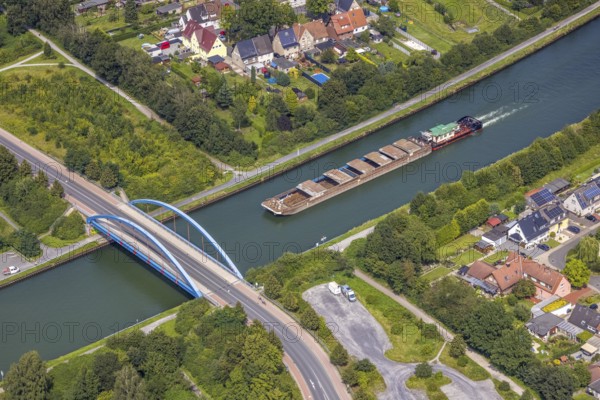 Aerial view, cargo ship on the Datteln-Hamm canal at the Werner Straße bridge in Rünthe, Bergkamen, Ruhr area, North Rhine-Westphalia, Germany, inland navigation, federal road B233, DE, Europe, goods transport, goods traffic, cargo ships, aerial view, aerial photography, aerial photography, shipping, shipping traffic, overview, bird's eye view, Werner Straße bridge, birds-eyes view, overview