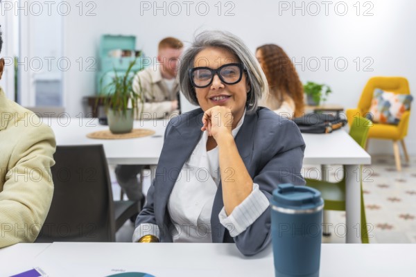 Experienced senior businesswoman smiling confidently during a meeting in a modern office, representing professionalism, leadership, and successful collaboration among diverse team members