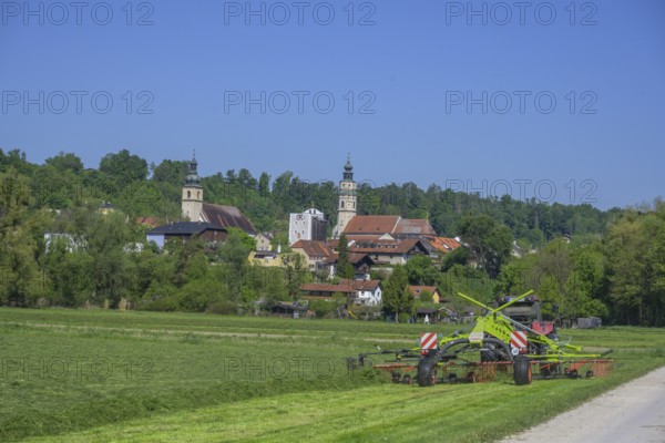 Tractor working in the field behind the village, Tittmoning, Bavaria, Germany