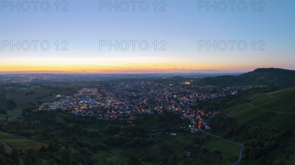 Panoramic view of a town at sunset, with illuminated streets and surrounding hills, Korb im Remstal, Baden-Württemberg, Germany