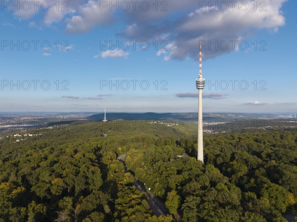 Television tower rises out of lush forest, surrounded by blue sky and decorated with clouds, Stuttgart-Degerloch, Baden-Württemberg, Germany