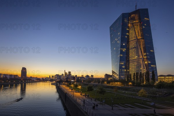 The lights of the European Central Bank (ECB) and the Frankfurt banking skyline glow in the evening, Osthafen, Frankfurt am Main, Hesse, Germany