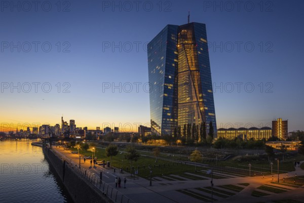 The lights of the European Central Bank (ECB) and the Frankfurt banking skyline glow in the evening, Osthafen, Frankfurt am Main, Hesse, Germany