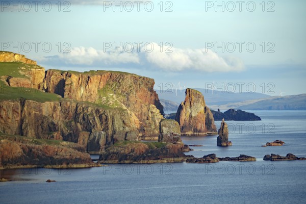 Cliffs and rock formations by the sea with wind turbines in the background, Eshaness, Shetland Islands, Scotland, Great Britain